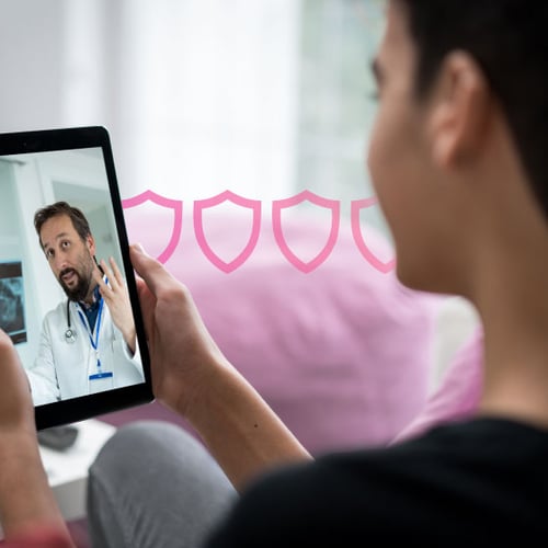 Photo of a female patient at home looking at her tablet. On the screen is a doctor discussing the patient's health situation. 