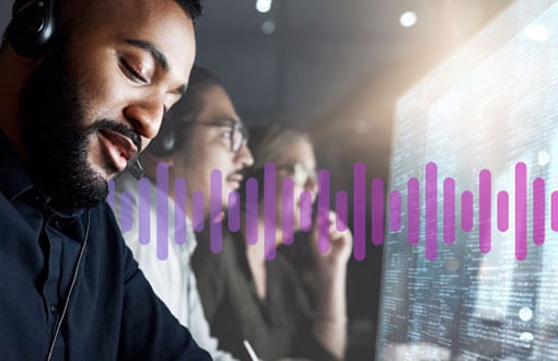 Advanced capabilities - details grid Man wearing a headset working in front of a computer screen displaying data, as a man and woman colleague work in the background