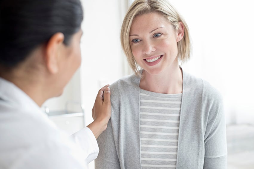 Female doctor with hand on patient's shoulder.