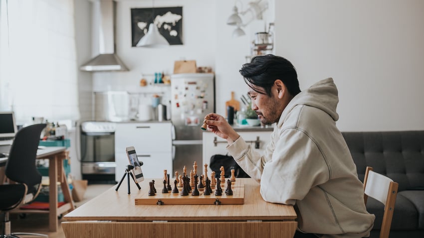 man in apartment plays chess over live video