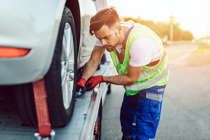 Man fixing wheel of disabled car